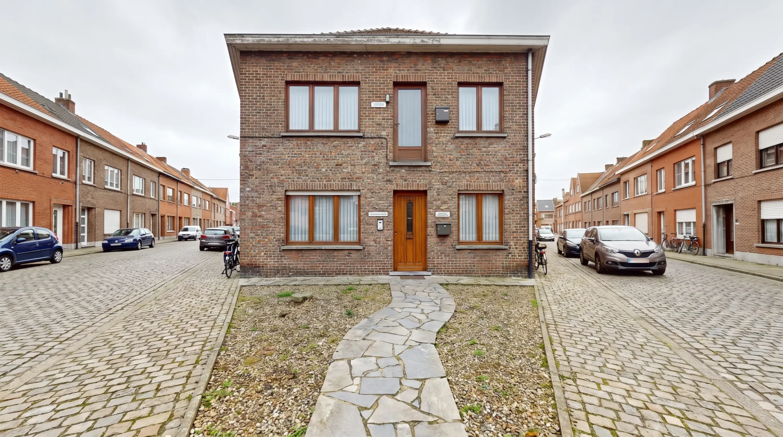Een Vlaams huis met twee afzonderlijke ingangen toont hoe een woningsplitsing de afbakening van appartementen en hun EPC-verplichtingen verandert.